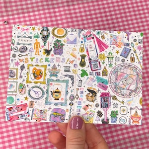 May include: A sticker sheet featuring a dense collage of colourful illustrations including a teapot, scissors, keys, a treasure chest, a library card, and the text "CRAFT STICKERS" and "Create your own reality" in various fonts and styles.