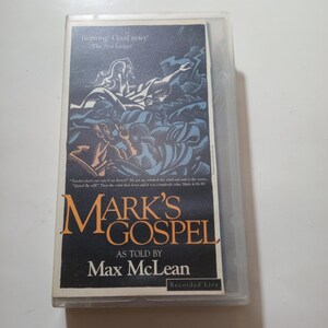 May include: A VHS cassette tape with a blue and white illustration of people on the front. The title is "Mark's Gospel as told by Max McLean" and the text "Recorded Live" is at the bottom.