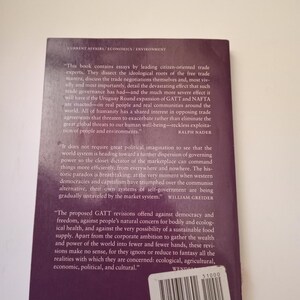 May include: A book cover with a purple background and white text. The book is about trade agreements and their impact on people and the environment. The text includes quotes from Ralph Nader and William Greider.