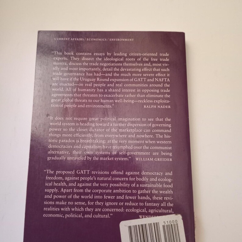 May include: A book cover with a purple background and white text. The book is about trade agreements and their impact on people and the environment. The text includes quotes from Ralph Nader and William Greider.