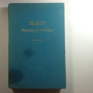 May include: A teal-colored book titled "SLEEP Physiology & Pathology" in gold lettering. The book's cover has a slightly textured appearance. The author's name is printed at the bottom of the cover.