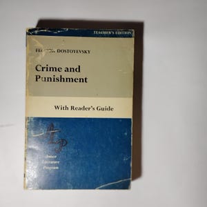 May include: A vintage copy of Fyodor Dostoevsky's "Crime and Punishment" with a reader's guide. The book has a blue and beige cover with the text "Teacher's Edition" at the top. The Amsco Literature Program logo is visible.