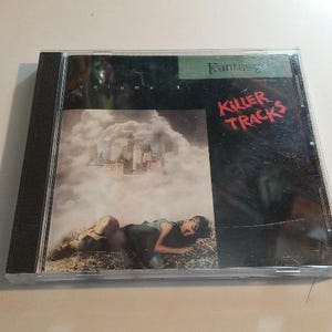 May include: A black CD case with a white and black image of a person lying in a field of grass. The text "Fantasy Volume 1 Killer Tracks" is printed on the case.