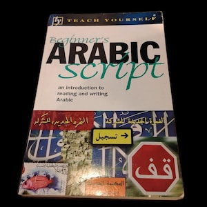 May include: A book titled "Beginner's Arabic Script" with the words in large, bold, black and green letters. The cover includes Arabic text and images, including a stop sign and a fish. The book is an introduction to reading and writing Arabic.