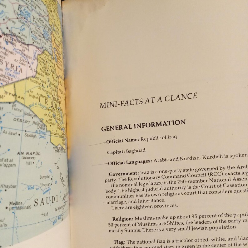 Puede incluir: Una p&aacute;gina de un libro sobre Irak con un mapa del pa&iacute;s y texto sobre la informaci&oacute;n general del pa&iacute;s, incluyendo su nombre oficial, su capital, sus idiomas, su gobierno, su religi&oacute;n y su bandera. El texto indica que el nombre oficial del pa&iacute;s es la Rep&uacute;blica de Irak, que la capital es Bagdad, que los idiomas oficiales son el &aacute;rabe y el kurdo, que el gobierno es un estado de partido &uacute;nico gobernado por el partido &aacute;rabe, que la religi&oacute;n es el islam y que la bandera es un tricolor de rojo, blanco y negro con cinco estrellas de cinco puntas verdes en el centro.