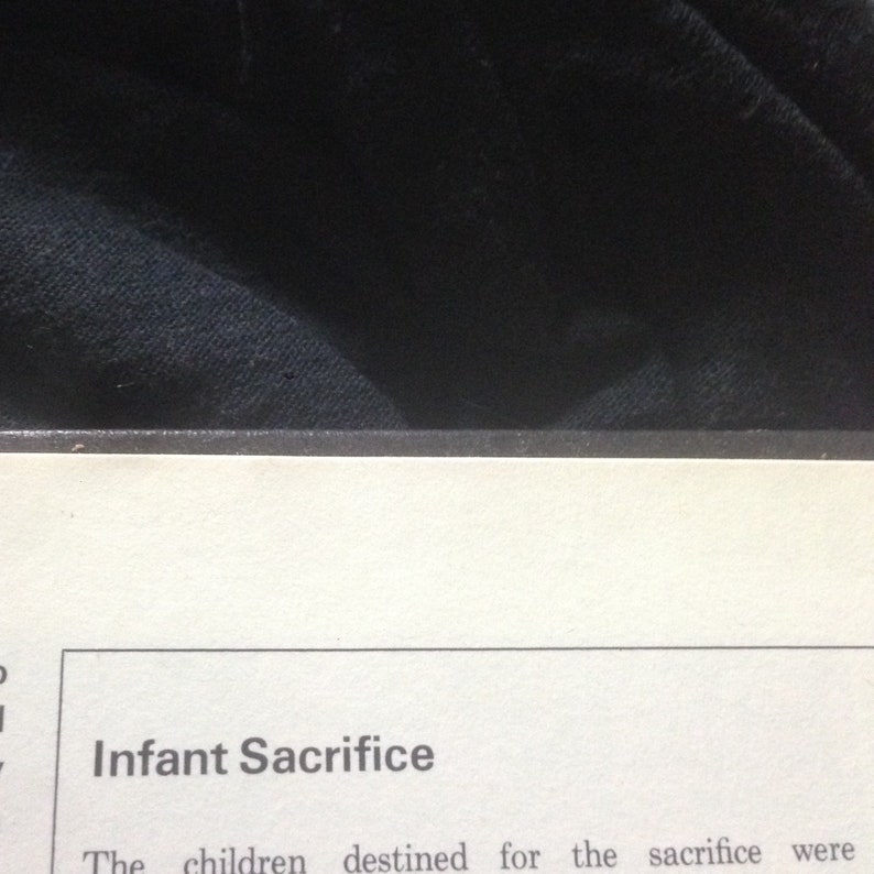 May include: A close-up of a page from a book with the heading "Infant Sacrifice". The text reads "The children destined for the sacrifice were"