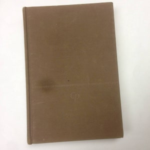May include: A brown book with a plain cover and the letter "G" written on it.