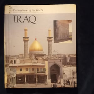 Puede incluir: Un libro titulado "Enchantment of the World: IRAQ" con una foto de una mezquita con una c&uacute;pula dorada y dos minaretes. La foto est&aacute; tomada desde un &aacute;ngulo alto y muestra la mezquita rodeada de edificios.