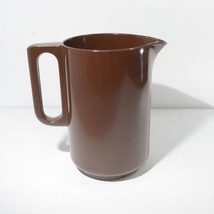 May include: A brown plastic jug with a handle.