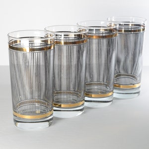 May include: Set of four clear glass highball glasses with black and gold striped designs.