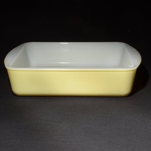 Peut inclure: Un plat à four en verre jaune avec un intérieur blanc. Le plat est rectangulaire et a un bord légèrement arrondi.