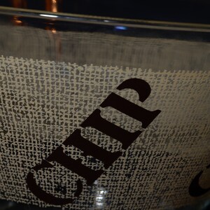 Puede incluir: Un taz&oacute;n de vidrio transparente con una textura de arpillera y la palabra "Chip" impresa en negro en el lateral.