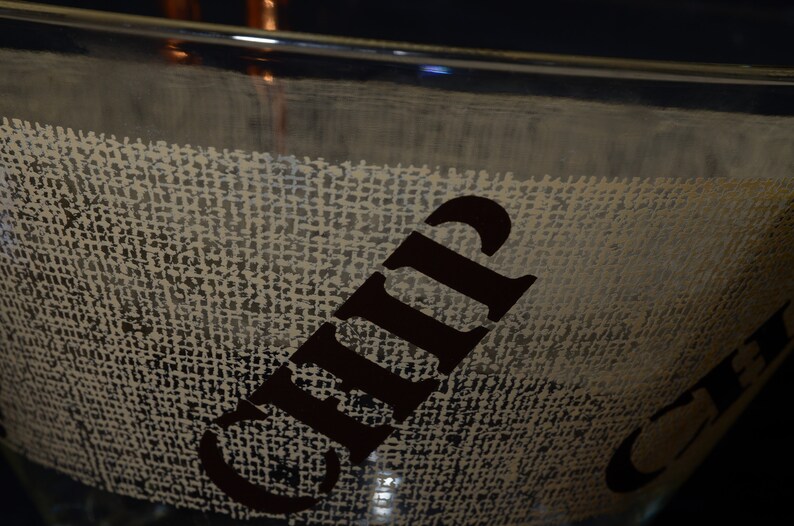 Puede incluir: Un taz&oacute;n de vidrio transparente con una textura de arpillera y la palabra "Chip" impresa en negro en el lateral.