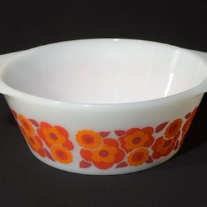 Könnte beinhalten: Weiße, ovale Servierschüssel mit zwei Griffen. Die Schüssel hat ein Blumenmuster in Orange- und Rottönen auf der Außenseite. Die Schüssel ist wahrscheinlich aus Glas oder Keramik.