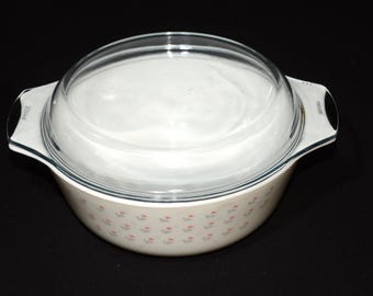 May include: White ceramic casserole dish with a floral pattern and a clear glass lid.