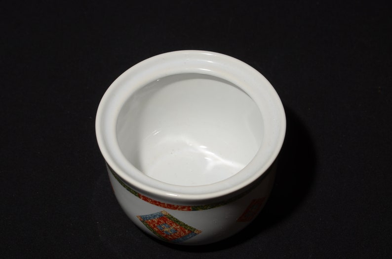 Puede incluir: Azucarero de cer&aacute;mica blanca con tapa. El bol tiene un patr&oacute;n geom&eacute;trico colorido en el exterior.