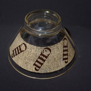 Puede incluir: Un bol de vidrio transparente para chips y salsa con una textura de arpillera y la palabra "Chip" impresa en marr&oacute;n en los lados.