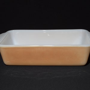 May include: A rectangular baking dish with a peach-coloured exterior and a white interior. The dish has two small handles. A classic piece for baking and serving, ideal for the kitchen.