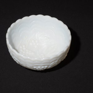 K&ouml;nnte beinhalten: Eine wei&szlig;e Schale mit gewelltem Rand und einem Traubenmuster. Die Schale besteht aus undurchsichtigem Glas und hat eine strukturierte Oberfl&auml;che. Die Schale ist wahrscheinlich Vintage und eignet sich zum Servieren kleiner Portionen.