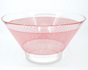 Könnte beinhalten: Eine klare Glasschale mit ausgestellter Form und breiter Öffnung. Die Schale ist mit horizontalen roten Streifen verziert, die die Schale umrunden. Die Schale steht auf einem klaren, kreisförmigen Sockel.