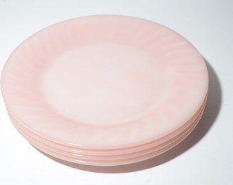 Puede incluir: Una pila de tres platos de postre de vidrio rosa con un diseño de remolino.