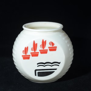 Op de afbeelding: Witte keramische pot met een ronde vorm en een gestructureerd oppervlak. De pot heeft een ontwerp van rode potplanten en een zwart-witte afbeelding. De pot heeft een brede opening en wordt waarschijnlijk gebruikt voor opslag of decoratie.