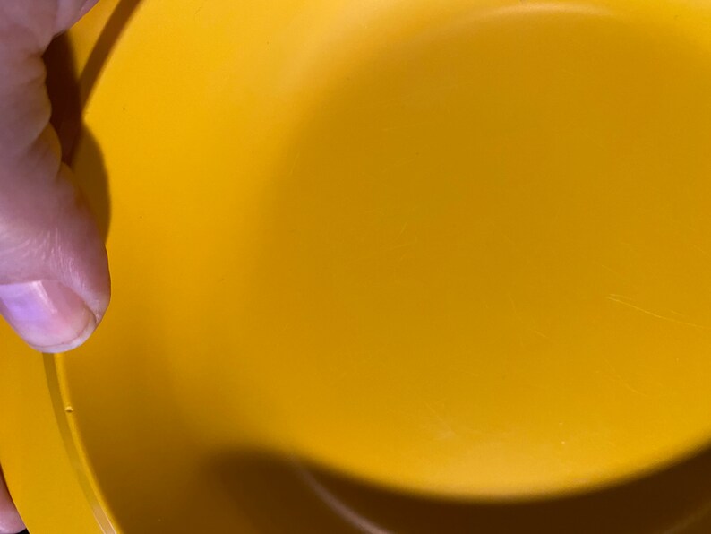 May include: A yellow plastic bowl with a smooth surface. The bowl is empty and appears to be new.