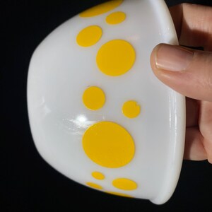 May include: White ceramic bowl with a yellow polka dot pattern.