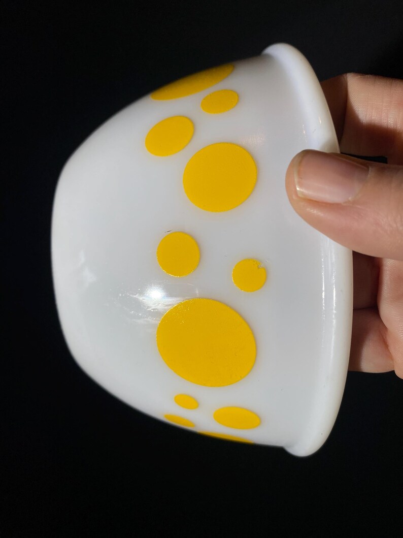 May include: White ceramic bowl with a yellow polka dot pattern.
