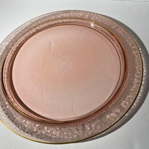 Puede incluir: Un plato de servir de vidrio rosa con un borde dorado y un delicado dise&ntilde;o grabado alrededor del borde.