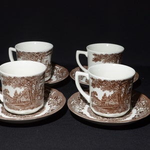 May include: Set of four brown and white teacups and saucers with a brown floral pattern. The cups and saucers have a vintage look.