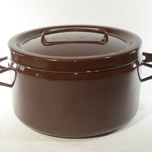 May include: A brown enamel pot with two black handles and a matching lid. The pot has a rounded shape and a smooth, glossy finish.