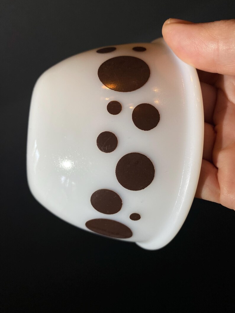 May include: White ceramic bowl with a brown polka dot pattern around the rim.