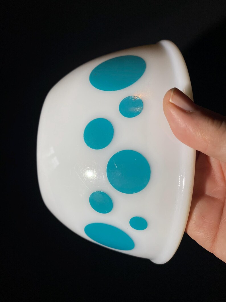 May include: White ceramic bowl with a teal polka dot pattern.