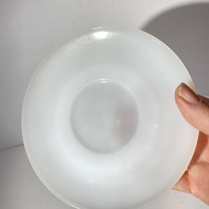 Może przedstawiać: Biały ceramiczny spodek o gładkim, błyszczącym wykończeniu. Spodek jest okrągły i ma lekko uniesiony brzeg.