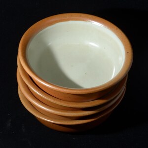 May include: A set of three ceramic mugs with a speckled, matte finish in cream, light grey, and dark grey. Each mug has a simple, minimalist design and a rounded handle.