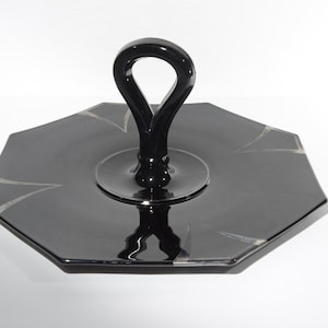 Może przedstawiać: Czarna szklana taca do serwowania o ośmiokątnym kształcie z czarnym szklanym uchwytem. Taca ma ozdobny wzór.