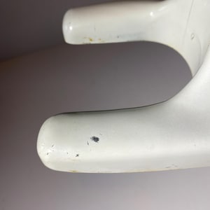 May include: White plastic base with a slight curve and a small black mark on the surface.