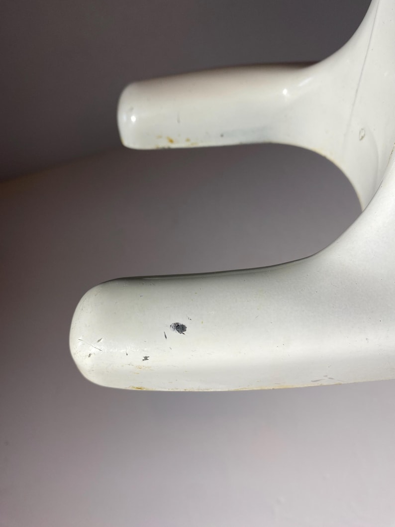May include: White plastic base with a slight curve and a small black mark on the surface.