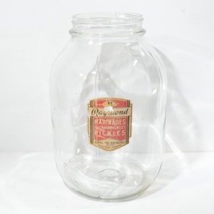 Peut inclure: Un bocal en verre transparent avec une étiquette rouge et blanche qui indique "Raymond Marinades All Sweet Pickles".