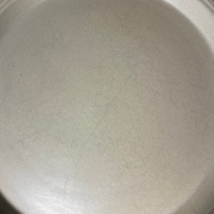 May include: A large, round, light gray serving platter with a brown and orange floral design around the rim.