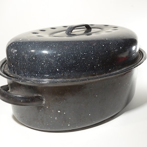 May include: Black enamel roasting pan with a speckled finish and a lid. The pan has a handle on the lid and two handles on the sides.
