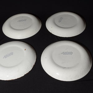 May include: Four white ceramic plates with a blue and white floral design. The plates are marked "The Hawthorne Collection" on the bottom.