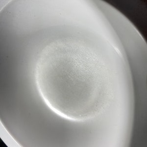 May include: A white ceramic bowl with a smooth, slightly textured surface. The bowl is empty and appears to be brand new.