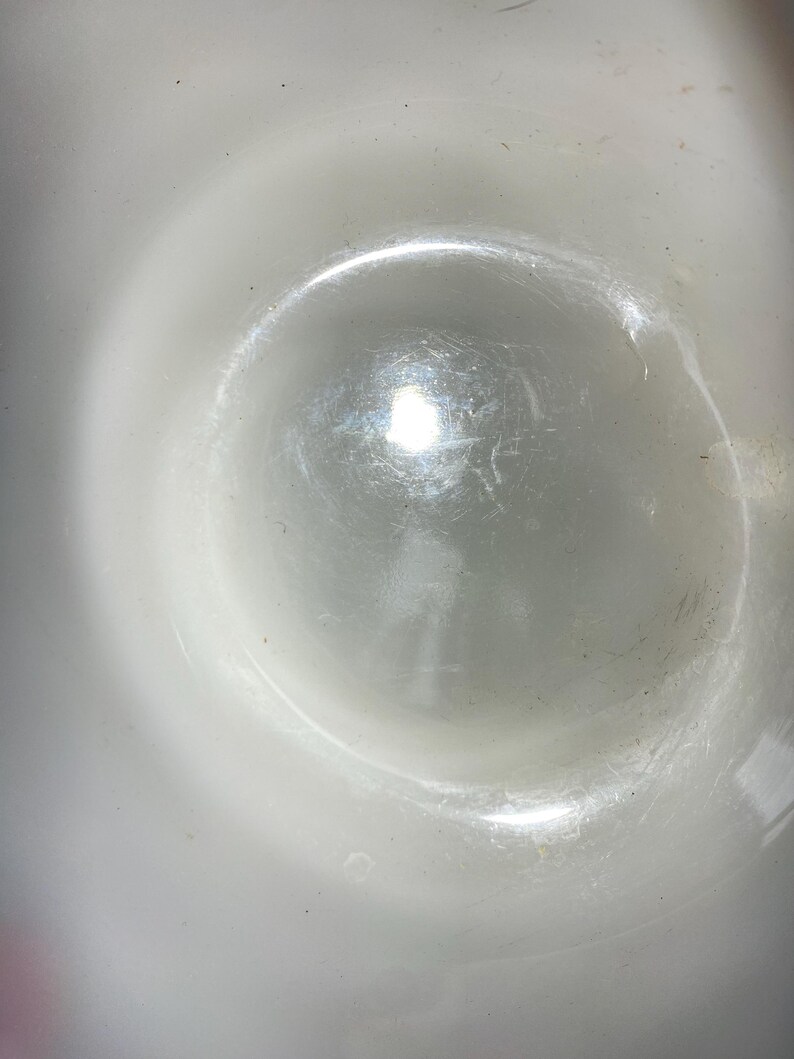 May include: A white ceramic bowl with a smooth, glossy finish. The bowl is empty and reflects light.
