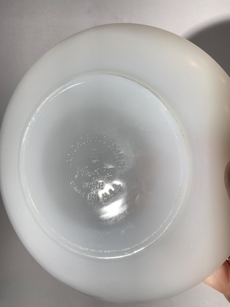 Może przedstawiać: Biała miska Pyrex z okrągłym wzorem na spodzie. Miska ma napis "Pyrex" i "Made in USA" nadrukowany na spodzie.