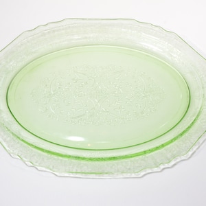 Può includere: Un piatto da portata ovale in vetro verde con un delicato motivo floreale. Il piatto ha un bordo ondulato ed è perfetto per servire antipasti, dessert o spuntini.