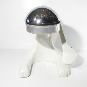 May include: White and chrome manual citrus juicer with a lever and the words "Juice King" on the top.
