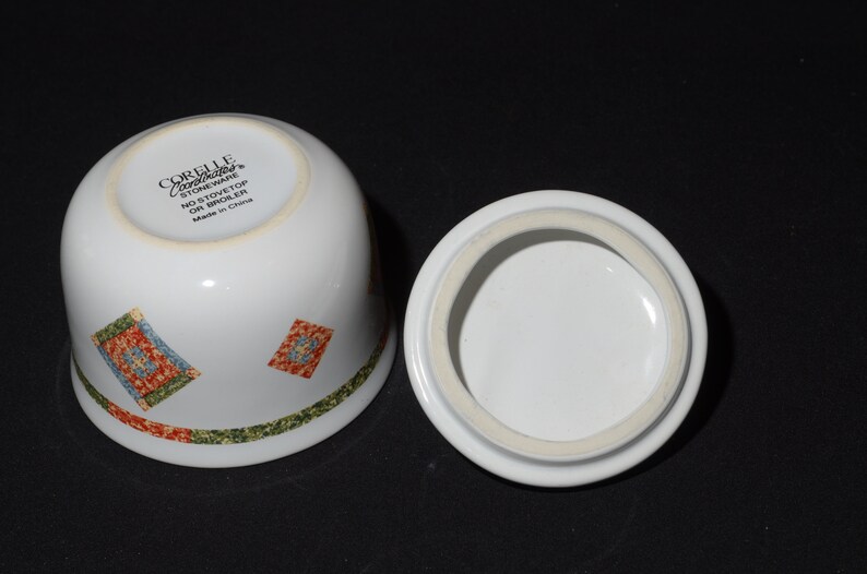 Puede incluir: Azucarero de cer&aacute;mica blanca con tapa. El taz&oacute;n tiene un patr&oacute;n geom&eacute;trico verde, rojo y azul. La parte inferior del taz&oacute;n tiene el texto "Corelle Coordinates Stoneware No Stovetop or Broiler Made in China".