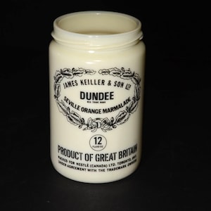 May include: A white ceramic jar with a black label that reads "JAMES KEILLER & SON LTD. DUNDEE SEVILLE ORANGE MARMALADE 12 PRODUCT OF GREAT BRITAIN PACKED FOR NESTLE (CANADA) LTD. TORONTO, ONT. UNDER AGREEMENT WITH THE TRADEMARK OWNER."